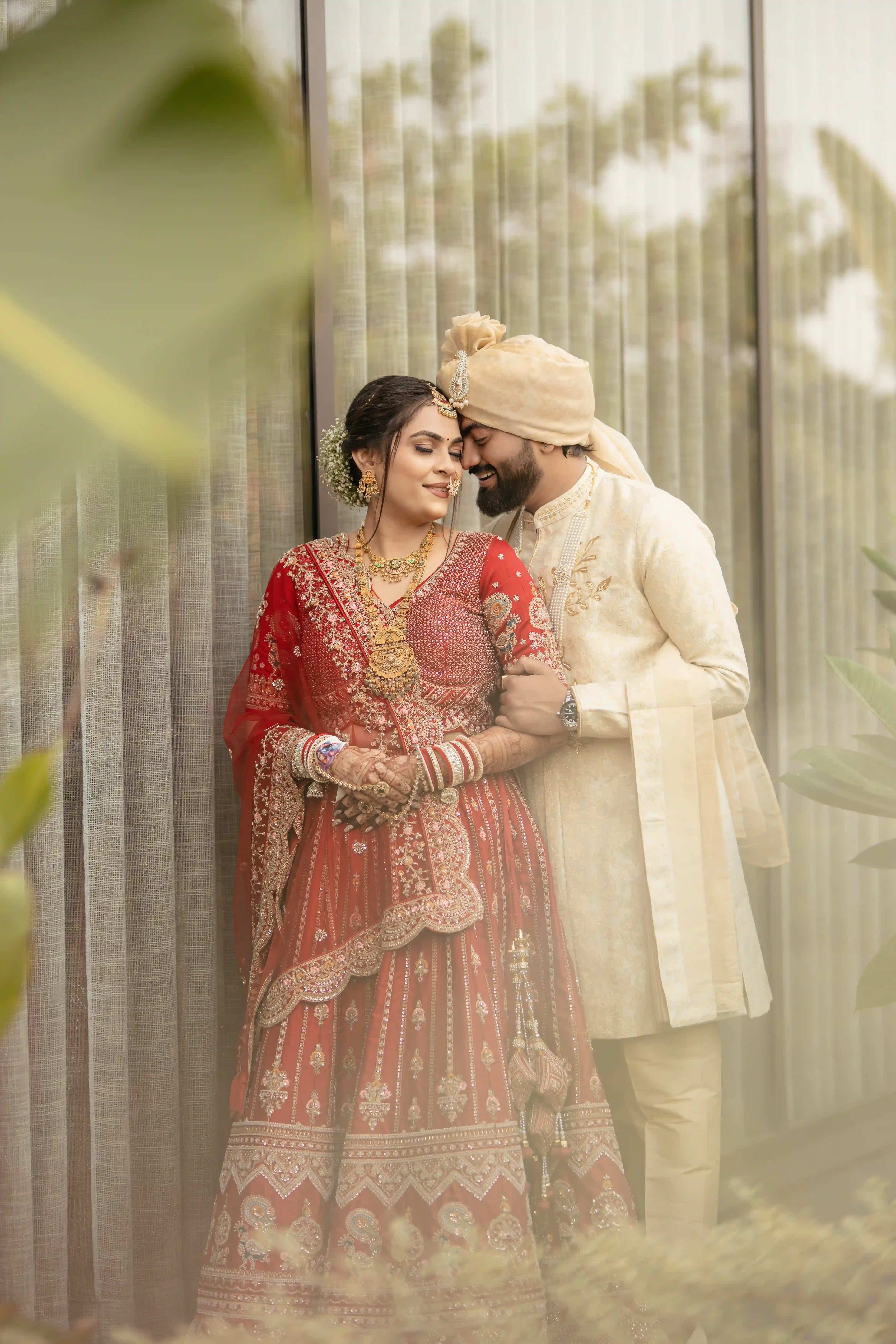 Newlywed couple sharing an intimate candid moment in traditional wedding attire